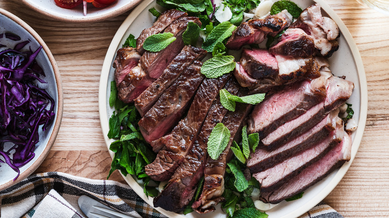 Plate of steak slices, covered with herbs