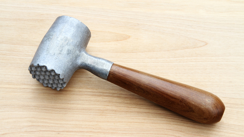 Meat mallet on wooden table
