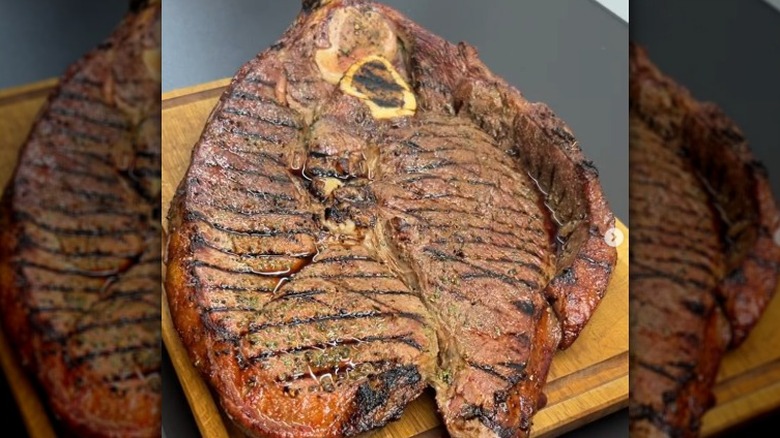 Cooked Tom and Jerry steak resting on wooden board