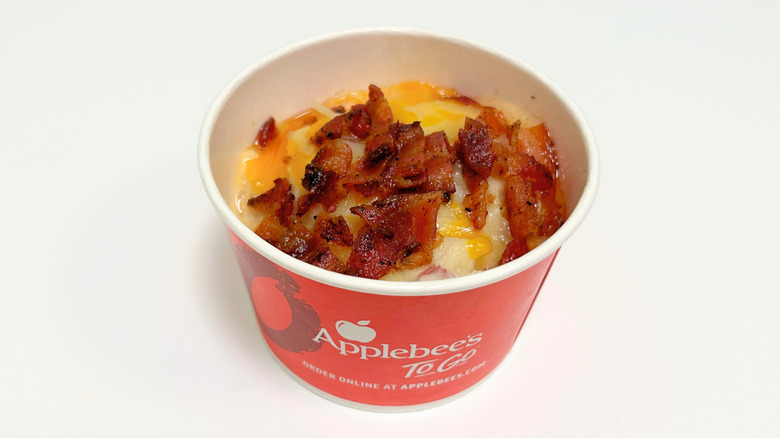 A to-go container of Applebee's Loaded Mashed Potatoes