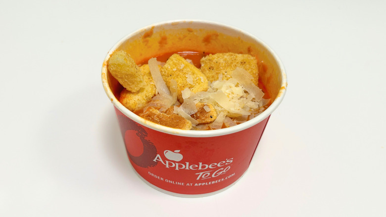A to-go container of Applebee's Tomato Basil Soup
