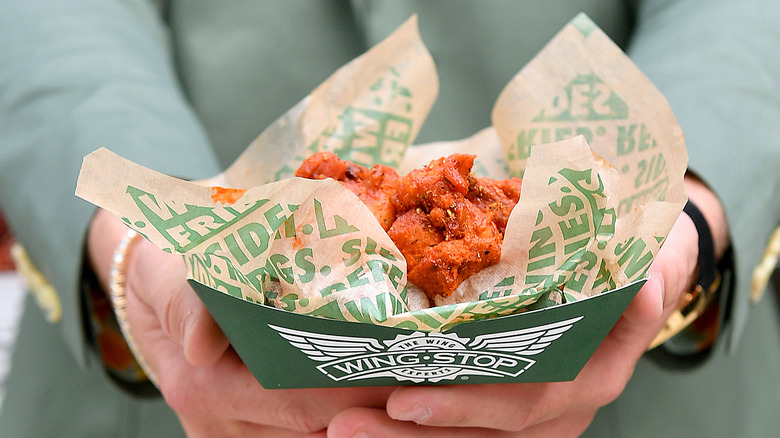 hands holding basket of Wingstop