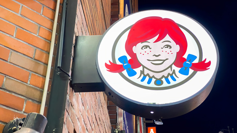 Building with a Wendy's restaurant circular sign with the face of Wendy.