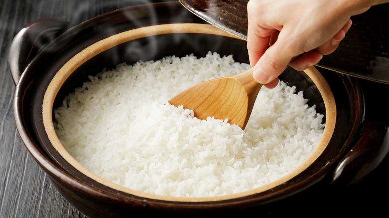 Person scooping rice out of pot