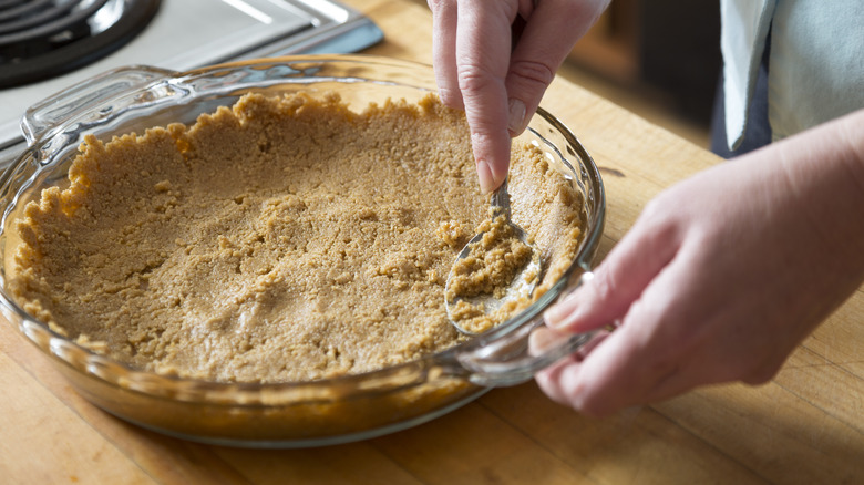 pressing cracker crust into pie dish