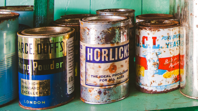Rusty cans on pantry shelf