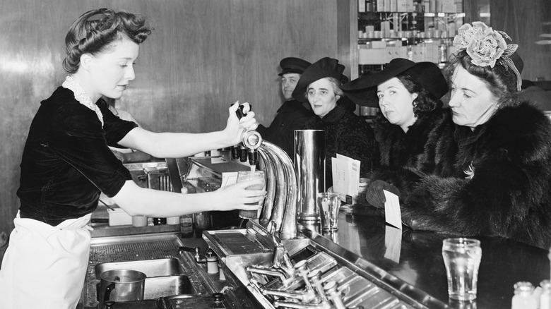 Woman serves drink at soda fountain