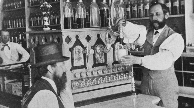 Server pours drink for customer at soda fountain