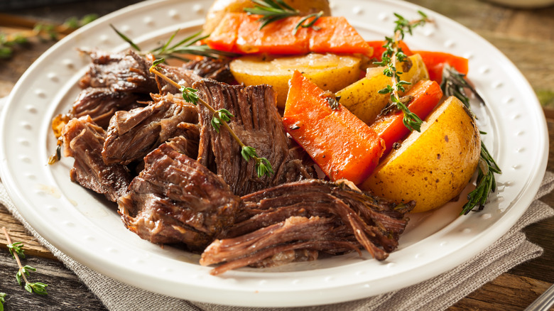 Pot roast on plate with carrots and potatoes