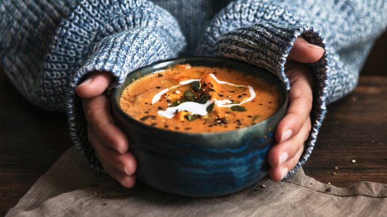 person holding bowl of soup