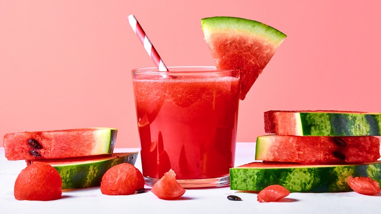 watermelon smoothie in a glass with striped straw