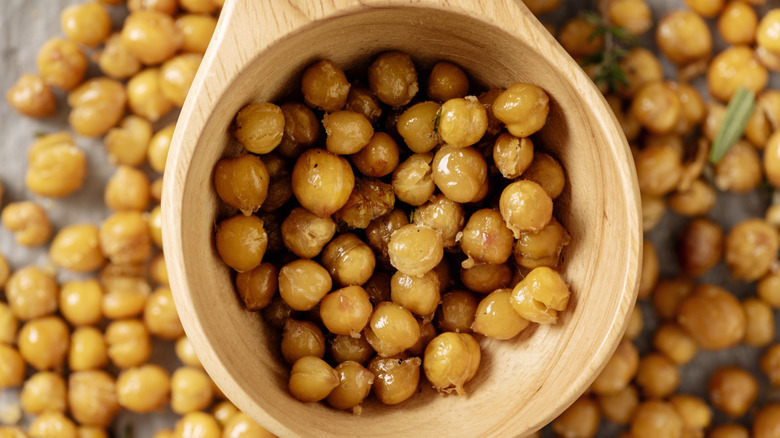 Roasted chickpeas in wooden spoon and in background