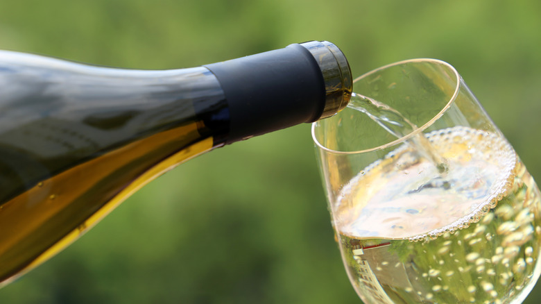 pouring white wine into glass