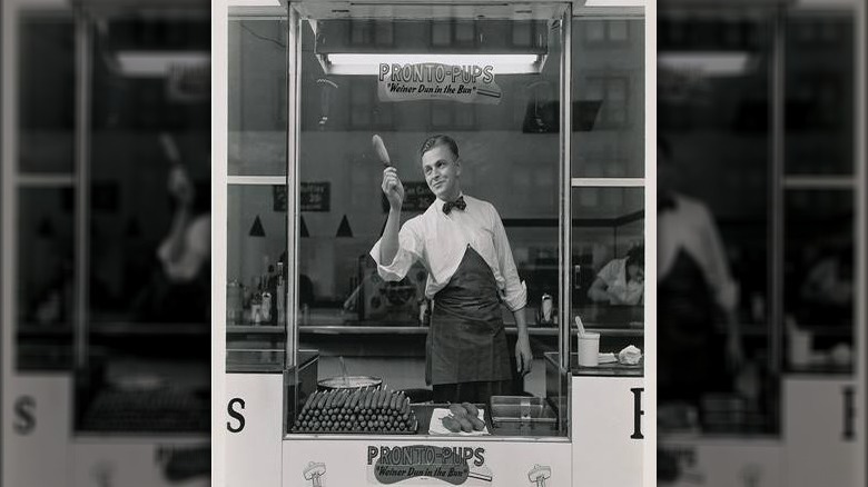 Pronto Pups marketing image of man holding pronto pup in the air