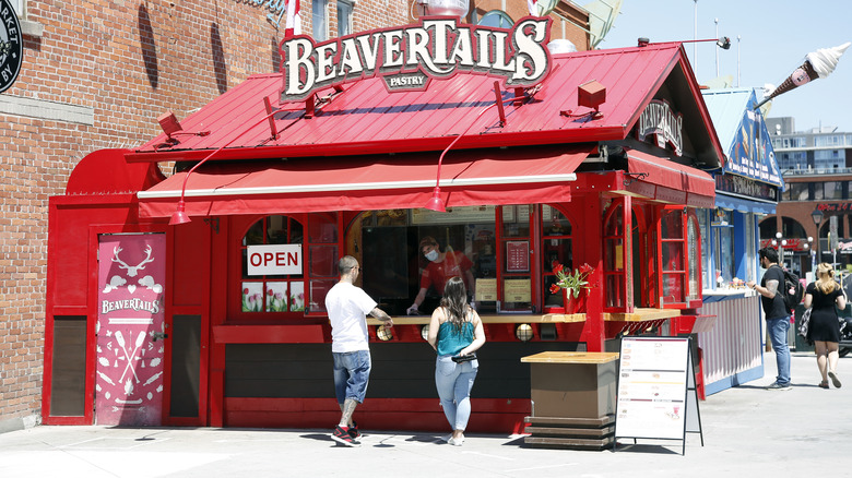 People in front of red beavertail stand