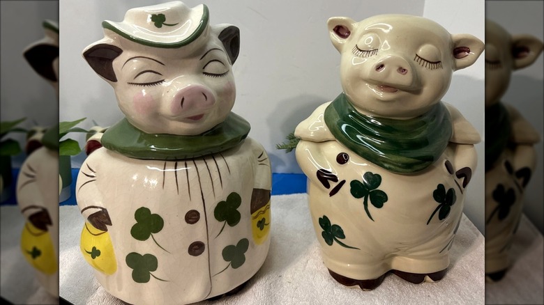 Shawnee Pottery pig cookie jars, girl pig wearing dress and hat with clovers and boy pig with green bandana and overalls