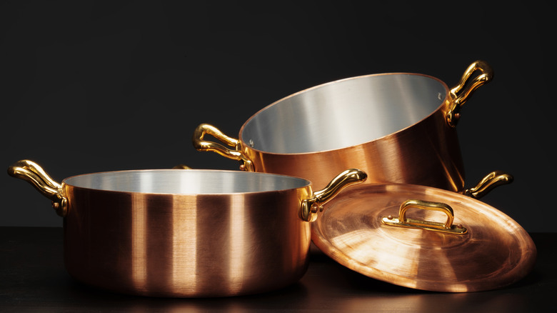 Set of copper cookware over dark background