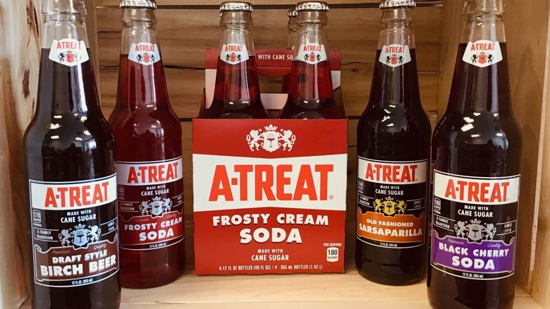 Variety of A-Treat soda flavors in glass bottles on in-store display