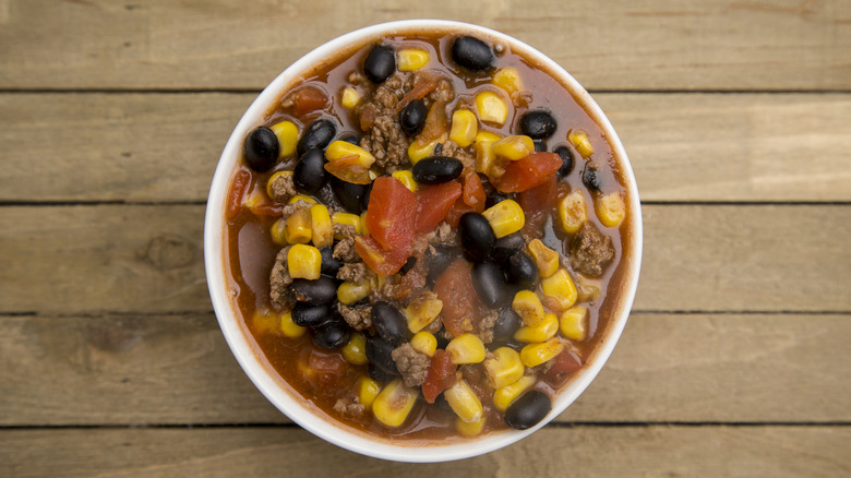 Cup of taco soup with beans, tomatoes, and corn