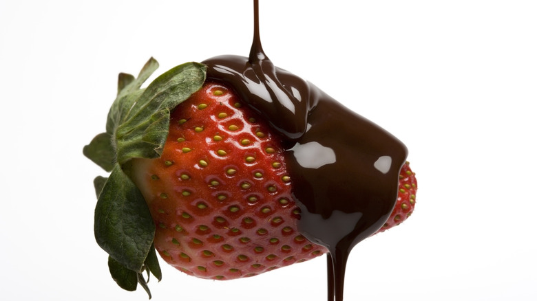 drizzling chocolate on a strawberry