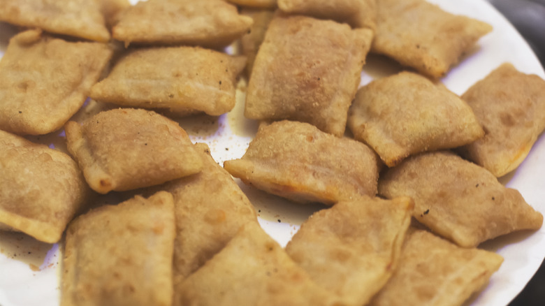 Pizza rolls on a white background at an angled view.