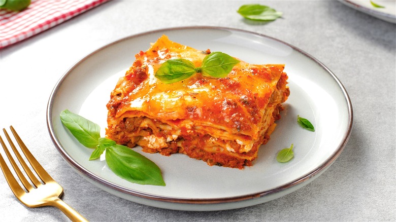 Piece of lasagna with fresh basil 