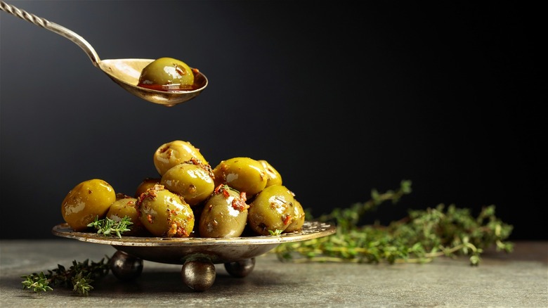 Marinated green olives with spoon 