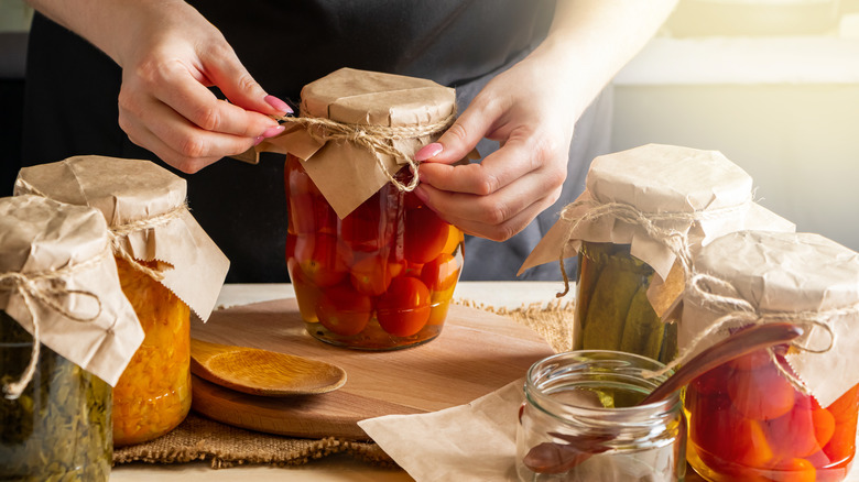 Hands sealing jar of pickled vegetables