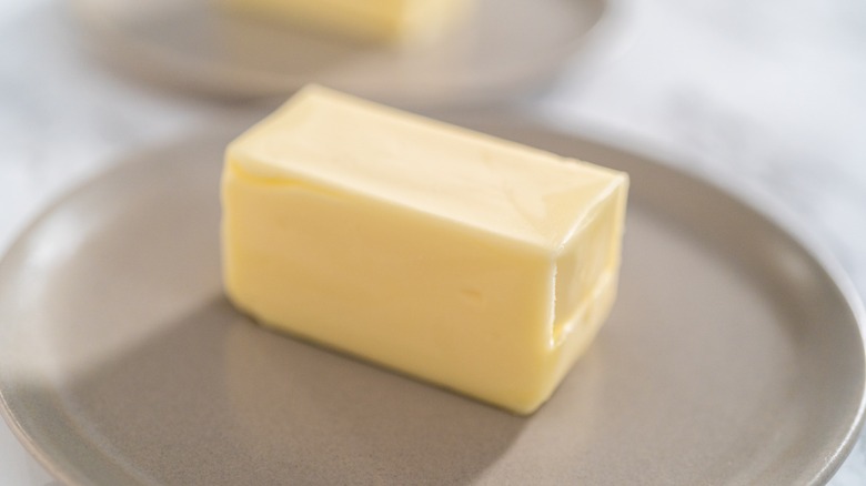 Stick of butter on gray plate 