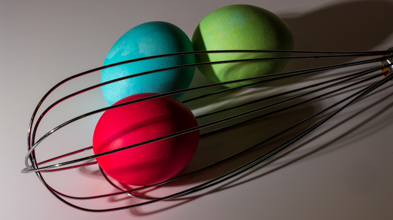 Dyed hard-boiled eggs and whisk