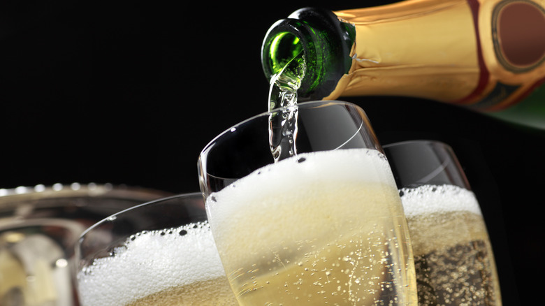 Bottle of champagne being poured into glasses