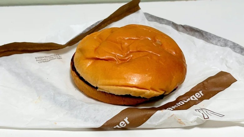 A flat-looking hamburger on a McDonald's wrapper.