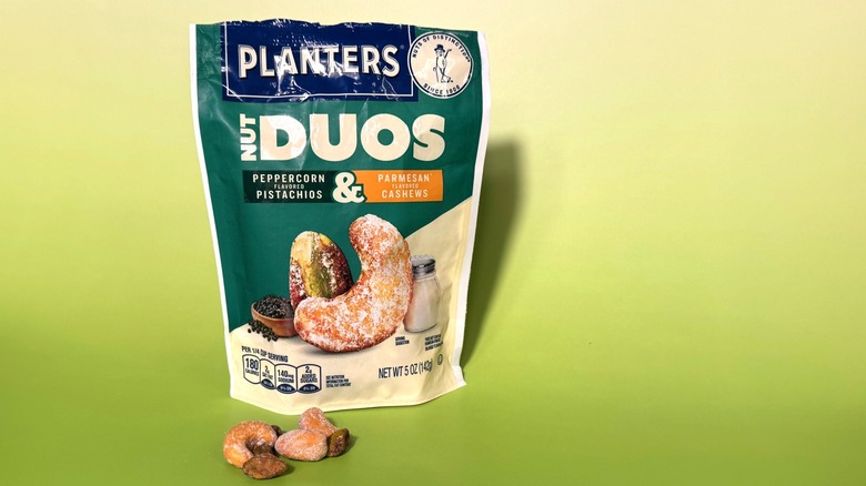 Planter's Peppercorn Pistachios and Parmesan Cashews on green background