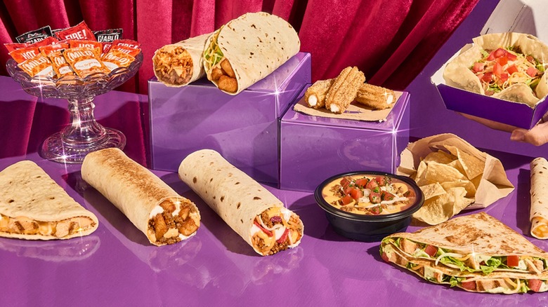 Taco Bell Luxe Value Menu items arranged on a purple and red curtain background