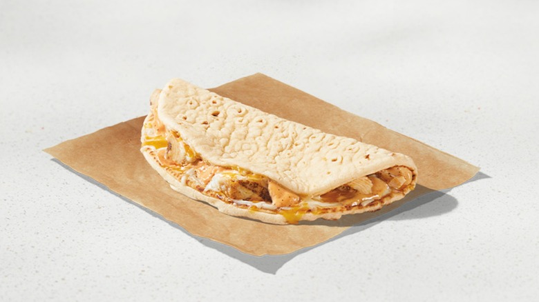Menu image of the 3 Cheese Chicken Flatbread Melt on a brown paper against a white background.