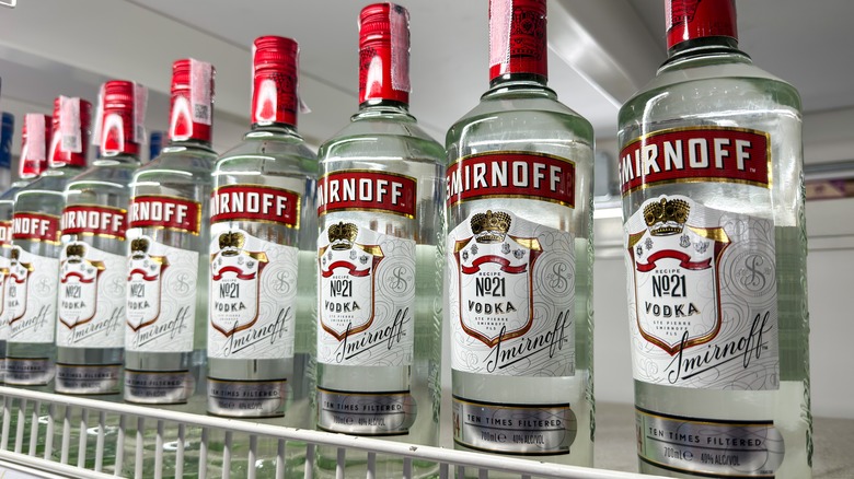 row of smirnoff vodka bottles on shelf