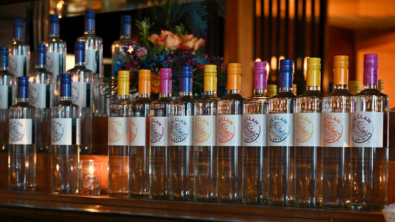 display of white various claw vodka bottles on bar