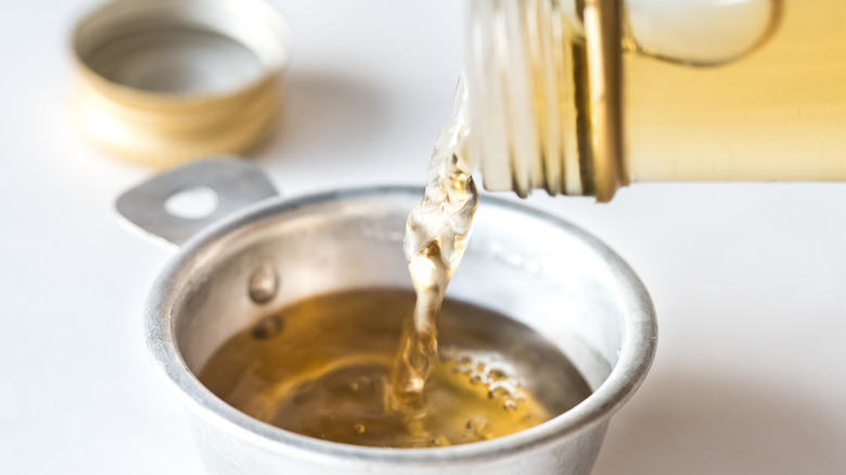 Wine wine vinegar is being poured into a measuring cup.
