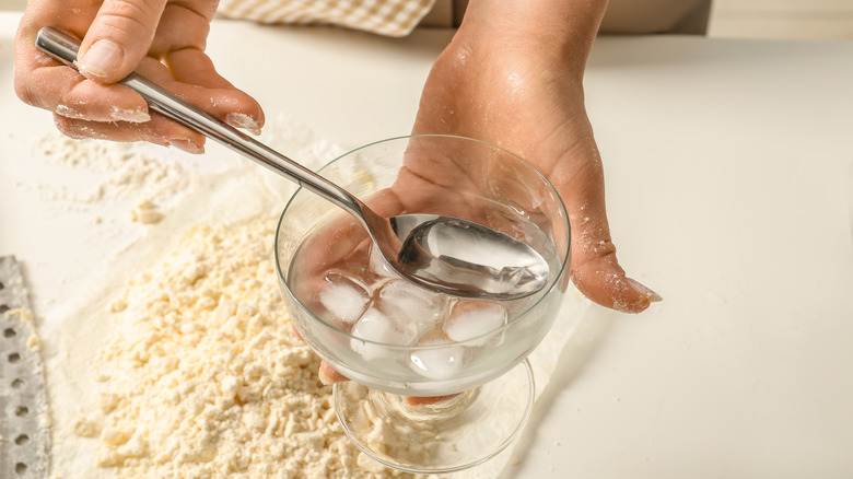 Ice water scooped to flour on work surface