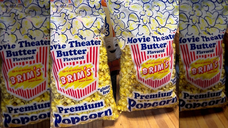 Two Brim's movie theatre popcorn bags propped up on wooden surface