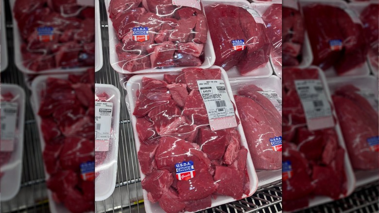 Choice-grade cubed raw stew meat in plastic packages on a shelf at Costco