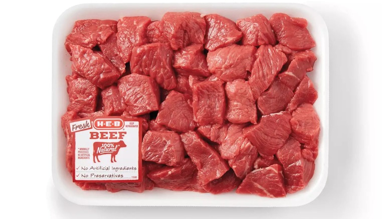 Cubed raw stew meat from H-E-B on a white background