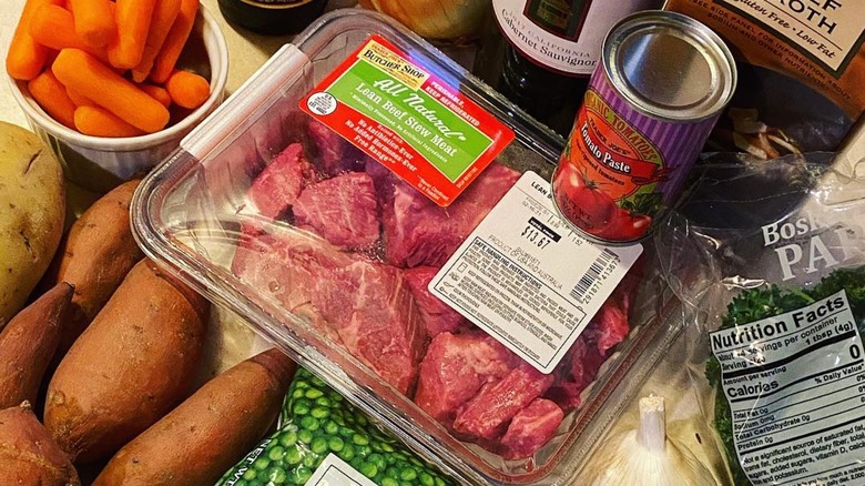 A package of Trader Joe's raw stew meat surrounded by other stew ingredients