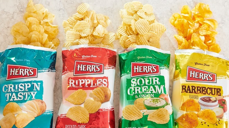 line-up of Herr's chip bags with potato chips spilling out of open tops