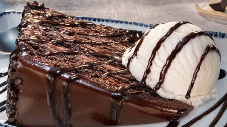 Chocolate cake slice served with a vanilla ice cream scoop