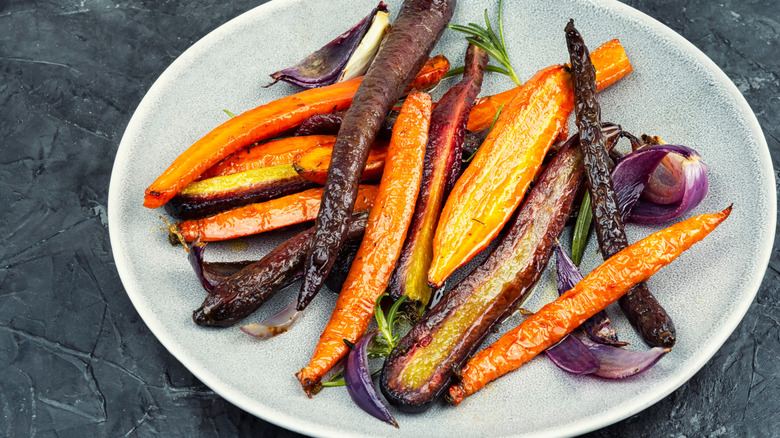 Roasted colorful carrots on a grey plate