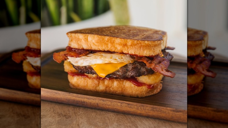Hardee's Frisco Breakfast Burger on a wooden board
