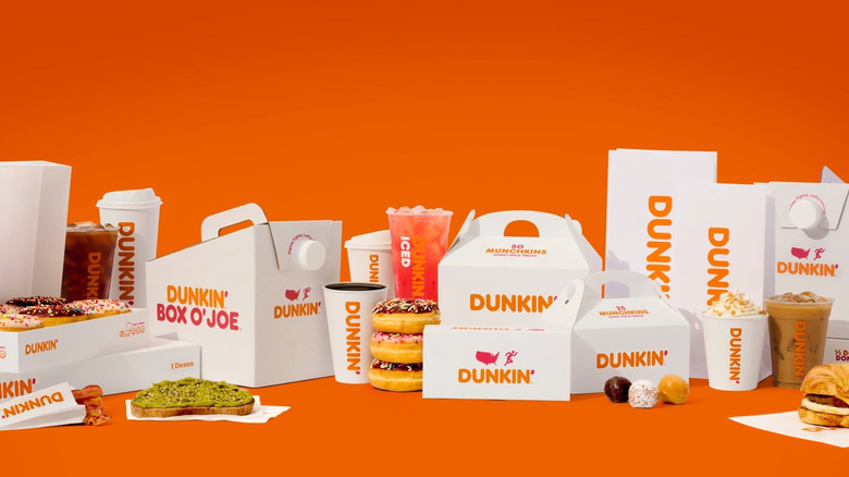 Variety of Dunkin' food and beverage items for breakfast on an orange background