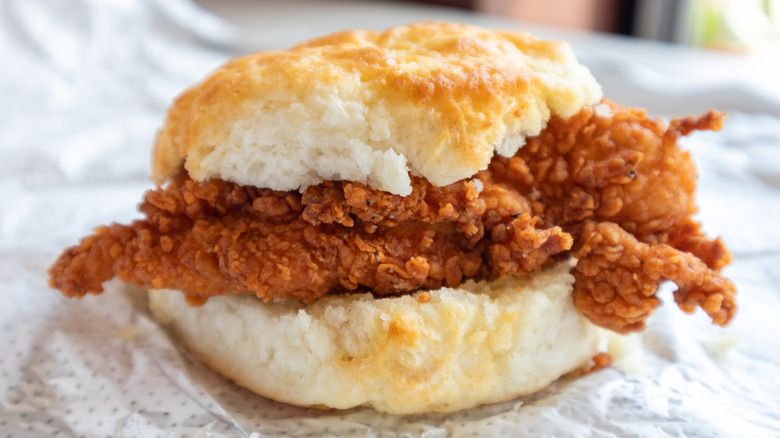 Close-up of a breakfast chicken biscuit on fast food wrapping