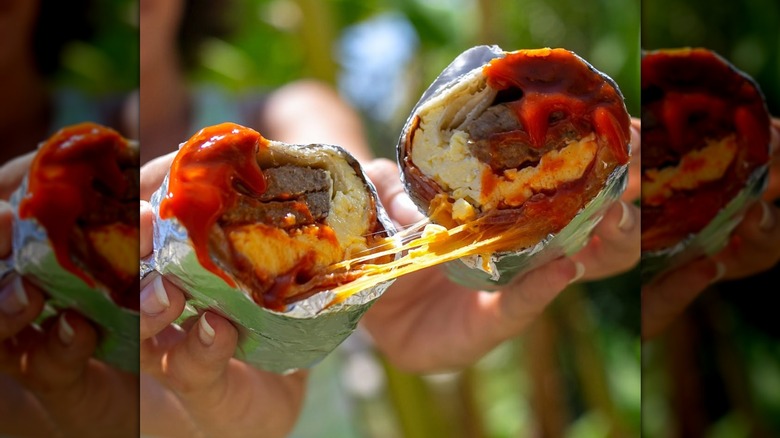 Close-up of a cheese pull in the Jack in the Box meat lovers breakfast burrito